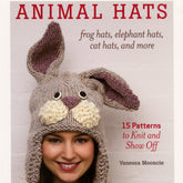 Cover of the book "Animal Hats - Frog Hats, Elephant Hats, Cat Hats, and More" by Vanessa Mooncie. The cover features a woman wearing a knitted rabbit hat complete with ears and large eyes. This book is published by Ingram Content and includes knitting patterns for various animal hats such as frog hats, elephant hats, cat hats, and more.