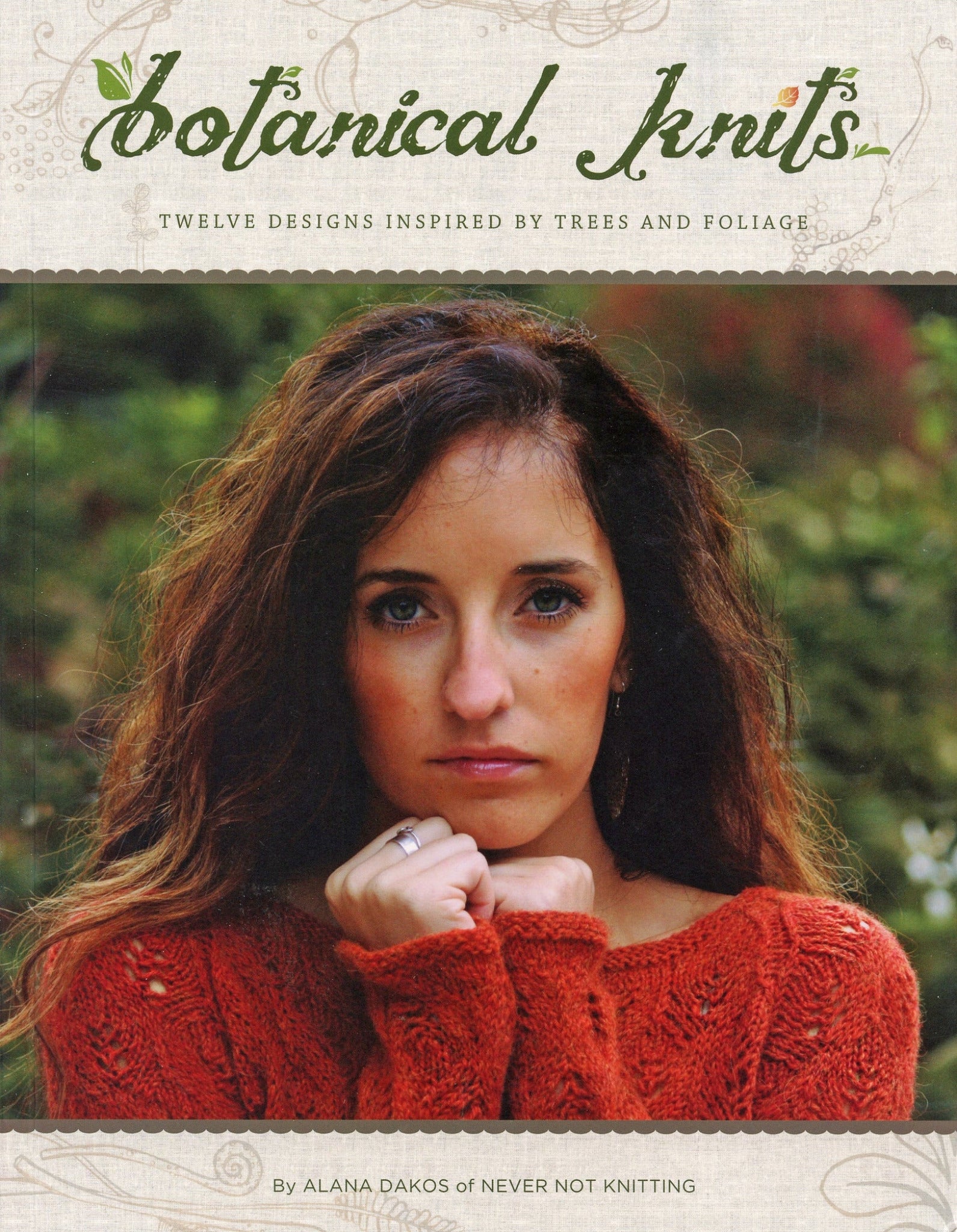 The cover of Never Not Knitting's "Botanical Knits" by Alana Dakos features a woman with brown hair wearing an elegant, red knitted sweater, standing amidst vibrant plant life.