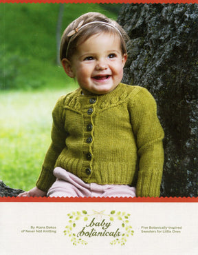 A cheerful baby sits against a tree trunk, dressed in a knitted green sweater adorned with buttons and light-colored pants. The book cover displays the title "Baby Botanicals" by Alana Dakos of Never Not Knitting, which includes five nature-inspired sweater designs for girls aged 6 months to 12 years.