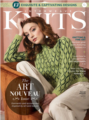 A woman with long auburn hair, dressed in a green patterned sweater, sits indoors and poses thoughtfully with her hand under her chin. The cover of the magazine reads “Interweave Knits Spring 2022” by Golden Peak Media, featuring innovative knitting designs by a renowned colorwork designer.