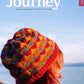 Cover of "Wool Journey: Shetland" by Pom Pom Publishing. Features a person with shoulder-length hair wearing a colorful knitted hat. The background displays a serene coastal landscape with a clear blue sky. Text: "Wool Journey: Shetland – A Knitter's Travel Guide, offering unique knitting patterns inspired by Shetland.”