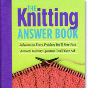 Cover of "The Knitting Answer Book - 2nd edition." The background is green and purple, with the title in large blue and yellow text. Below, it reads "Solutions to Every Problem You'll Ever Face, Answers to Every Question You'll Ever Ask." A knitted pink fabric is pictured at the bottom, reminiscent of what you'd find at your favorite yarn shop. Published by Workman Publishing - Storey.