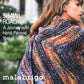 A woman draped in a thick, multicolored knit shawl looks away from the camera. The text on the image reads, "Malabrigo Book 13 - Shawl Road: A Journey with Hand-Painted Yarns," and "Malabrigo Yarn." The background is slightly blurred, with hints of greenery visible.