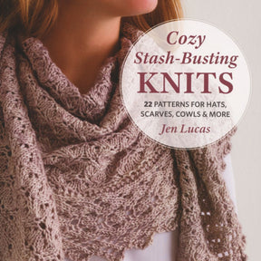 A woman wears a cowl with textured stitches. The text reads "Cozy Stash-Busting Knits - 22 Patterns for Hats, Scarves, Cowls & More" by Jen Lucas from Martingale & Co. The background is a plain, light color.