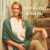 A smiling woman with long hair in a braid sits on stone steps outdoors, wearing light brown pants, a white blouse, and a teal knitted shawl. Against a wooden fence background in the top right corner, the words "Weekend Wraps" by Ingram Content are written in cursive.