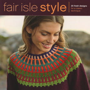 A woman is wearing a vibrant Fair Isle sweater from Ingram Content's "Fair Isle Style," adorned with an intricately patterned yoke design featuring red, green, orange, and blue geometric shapes. She gazes downward with a gentle smile. The top text reads "Fair Isle Style," highlighting the 20 fresh designs for modern uses of color in classic knitwear.