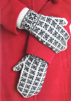 A person wearing a red coat and grey "Knit Like A Latvian" mittens by Ingram Content, featuring Latvian mitten knitting patterns, is seen in the image. The hands are crossed in front of the body, highlighting the intricate design of the mittens against the solid color of the coat.