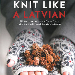 The cover of the book "Knit Like A Latvian" by Ingram Content displays a close-up image of hands adorned with patterned mittens, holding small pinecones. The subtitle reads, "50 knitting patterns for a fresh take on traditional Latvian mitten designs.