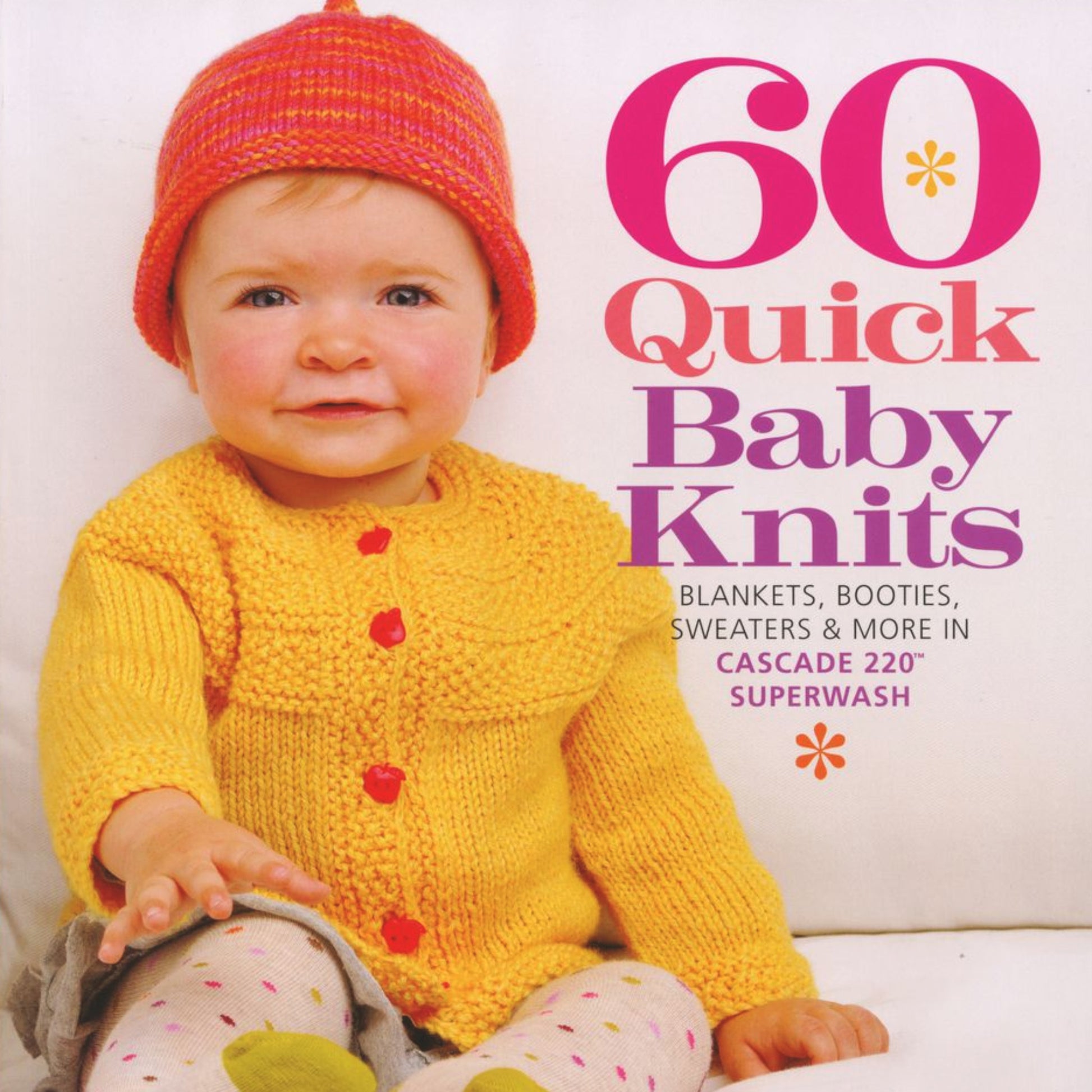 A baby wearing a knitted yellow cardigan and an orange and pink hat sits on a white surface, with the book "60 Quick Baby Knits" from Ingram Content, featuring the title "Blankets, Sweaters & More in Encore Cascade 220 Superwash" prominently displayed in bold text with pink and orange accents.