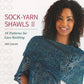 A book cover shows a woman smiling at the camera while modeling a blue lace-knit shawl with intricate patterns. The title reads "Sock-Yarn Shawls II - 16 Patterns for Lace Knitting" by Jen Lucas, published by Martingale & Co. Suitable for all skill levels, this collection showcases the beauty of knitting shawls with versatile sock yarn. The model has curly dark hair and exudes joy in her expression.