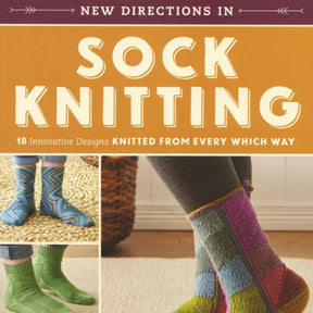 Cover of a book titled "New Directions in Sock Knitting: 18 Innovative Designs Knitted from Every Which Way" by Ingram Content, featuring three pairs of colorful knitted socks. Set against a warm background with yarn balls, knitting needles, and step-by-step instructions in the imagery.