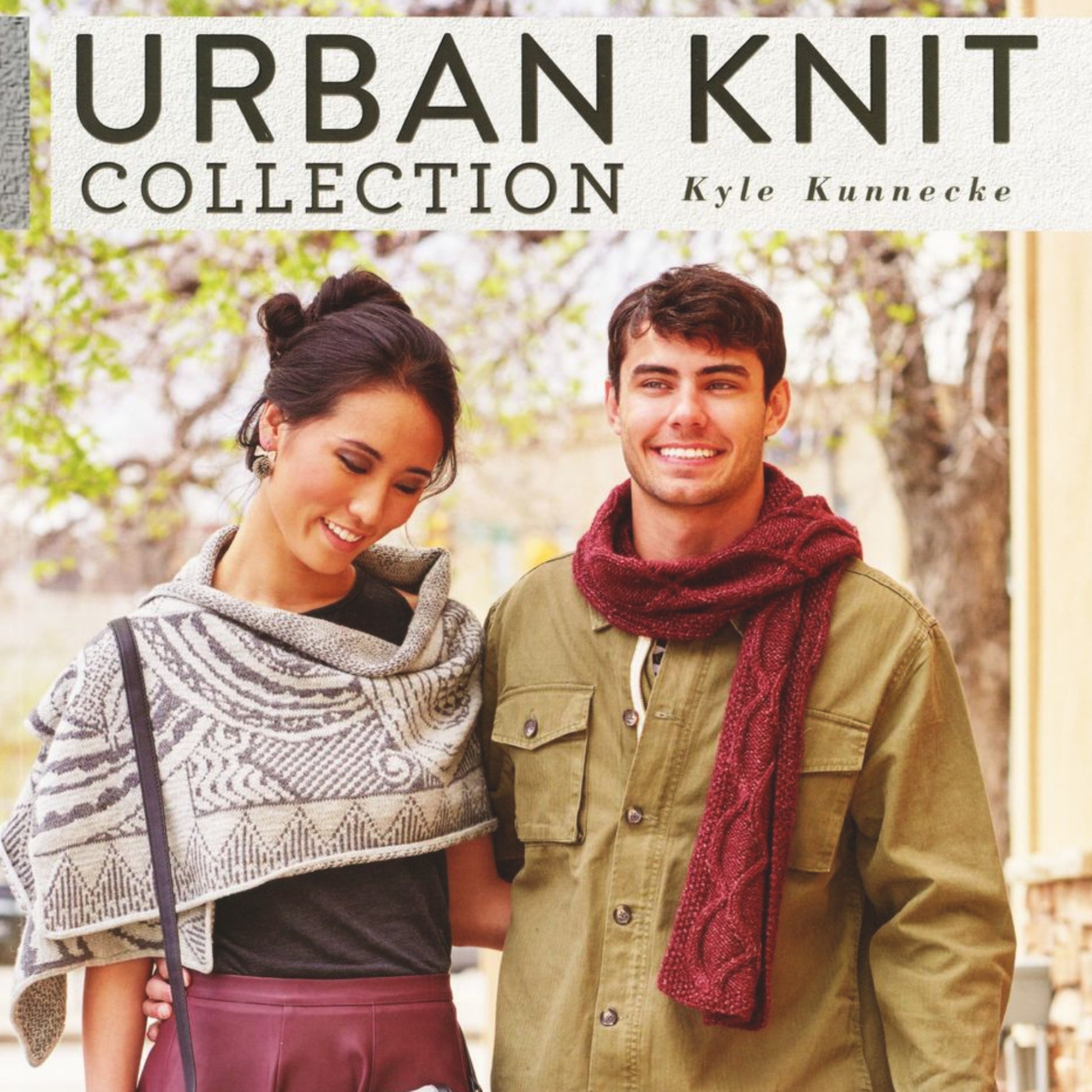 A magazine cover titled "Urban Knit Collection" by Ingram Content showcases a smiling couple outdoors, modeling fashionable knitted garments. The woman is adorned in a geometric patterned shawl, while the man sports a stylish scarf. Lush green trees serve as the picturesque background.