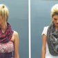 Two images of the same woman with blond hair styled in a ponytail, showcasing different scarves. On the left: A colorful, chunky knit scarf from the Noema Book by Louisa Harding paired with a floral dress. On the right: A muted, patterned scarf worn with a white shirt. Each image has a gray background.