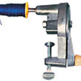 A close-up of the Leclerc Single-Ended Hand Bobbin Winder by Leclerc Looms, attached to a flat surface and effectively functioning as an economical bobbin winder. The winder is holding a spool of blue thread and includes an adjustable clamp for secure attachment. The background is plain and white.