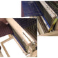 Close-up image of the Leclerc Swinging Beater Table Loom Conversion Kit by Leclerc Looms displaying two steps. Step 1 illustrates the positioning of the blue warp threads. Step 2 demonstrates pressing and holding of threads in place using a metal bracket. A brown, partially woven fabric is visible.