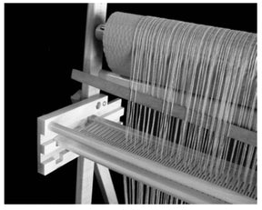 A close-up of the Leclerc Penelope II 22.5" Rigid Heddle Tapestry Loom from Leclerc Looms in black and white. Threads are meticulously arranged and stretched across this premium tapestry loom, showcasing the detailed craftsmanship involved in the weaving process. The loom, equipped with two rigid heddles, is positioned against a dark background.