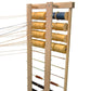 A Leclerc Thread Guide by Leclerc Looms holds multiple spools of thread in shades of yellow and blue. The threads, connected and stretched outward, are ready for weaving or another craft activity. The frame’s horizontal rods provide support, ensuring smooth operation.