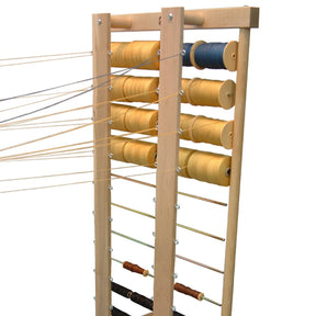 A Leclerc Thread Guide by Leclerc Looms holds multiple spools of thread in shades of yellow and blue. The threads, connected and stretched outward, are ready for weaving or another craft activity. The frame’s horizontal rods provide support, ensuring smooth operation.