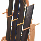 A Leclerc Looms Reed Stand / Rack that features multiple upright vertical black rigid heddle reeds and several horizontal wooden dowels for support and structure, doubling as an efficient reeds storage solution.