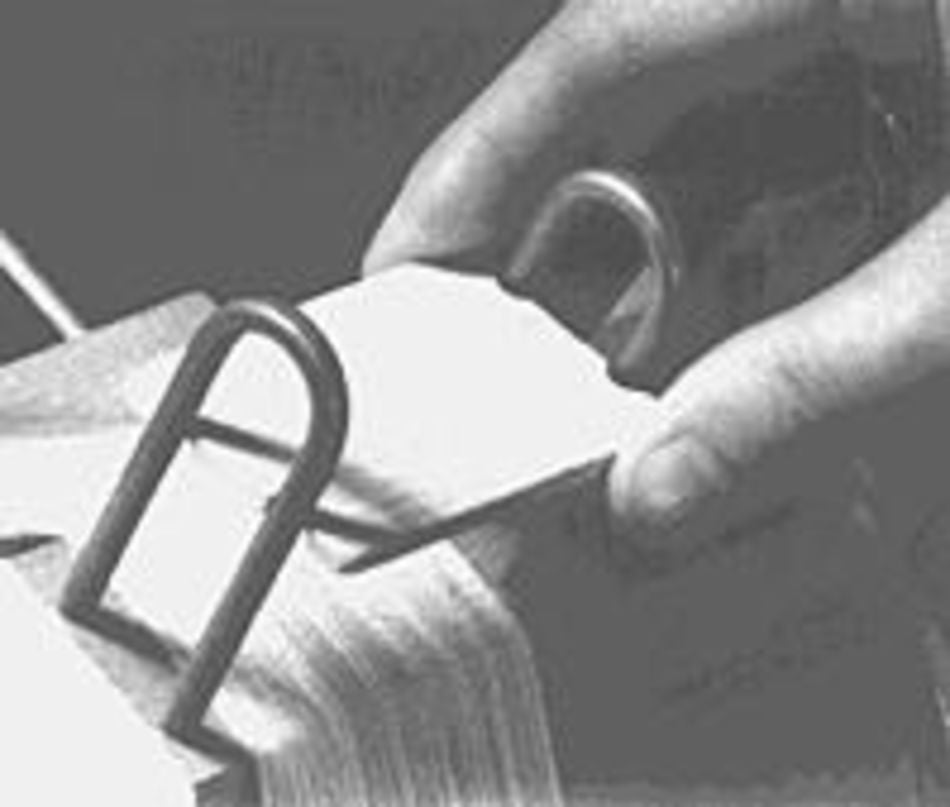 A close-up image shows someone's hands handling a set of Leclerc Sectional Warp Dividers held together by two metal rings, with a plastic divider separating sections. The person's fingers fan through the dividers, indicating they are organizing or searching through them.