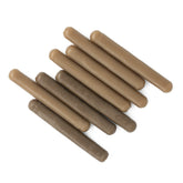 Nine cylindrical brown wax-like elements, similar to Leclerc Looms Shaft Frame Divider Pegs, are arranged diagonally on a white background. They range in shades from light to dark brown.