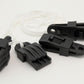 Four Leclerc Clip Temple accessories, made of black plastic with jagged teeth, are attached to a white cord and arranged on a plain white background. These innovative clips from Leclerc Looms feature a textured grip and an eyelet hole for secure attachment, making them ideal for use with Leclerc looms and other weaving projects.