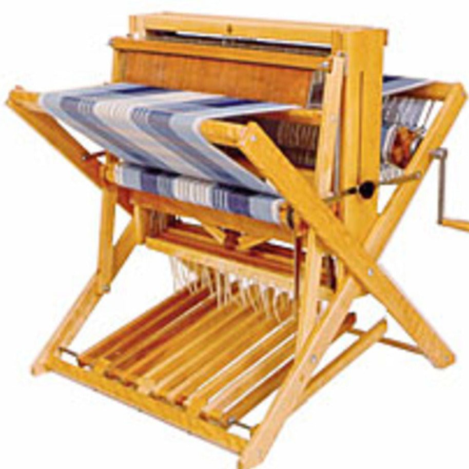 A Leclerc Compact 24" Floor Loom by Leclerc Looms, with a partially woven blue and white textile, is positioned on the loom frame. The loom features a beater at the front, heddles, treadles at the bottom, and a crank handle on the side.