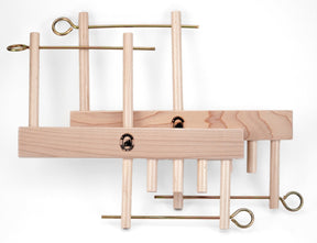 The Leclerc Threading Helper by Leclerc Looms features wooden weaving stick shuttles with brass hooks attached. Arranged in a staggered fashion against a white background, the natural wood grain is beautifully visible, while the metallic contrast of the brass hooks perfectly complements your threading tools.