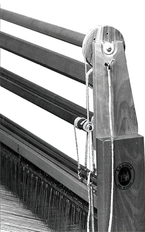 Black and white image of a Leclerc Shed Regulator's side section, showcasing visible wooden support beams, threads, and tightly aligned needles. A distinct Leclerc Looms logo is present on the bottom right of the loom's vertical support.