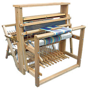 The Leclerc Nilus II 8-Shaft Floor Loom by Leclerc Looms is a wooden floor loom featuring an intricate assembly of levers, beams, and treadles used for weaving cloth. It showcases vibrant threads partially woven into fabric, demonstrating a pattern in progress.