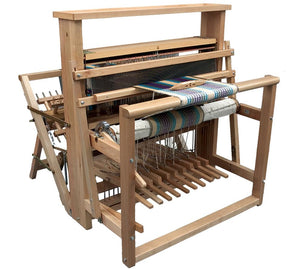 The Leclerc Nilus 8-Shaft 10-Treadle (Back Hinged) Jack Floor Loom by Leclerc Looms is shown with various components, including heddles, treadles, warp and weft threads, and a partially completed woven fabric with colorful patterns. The loom is designed for handweaving and is in a stationary position.