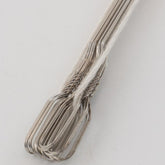 A close-up image of several silver Wire Repair Heddles (available in a 12-pack), from Leclerc Looms, neatly aligned and held together by white carpet warp. The background is plain and light-colored, focusing attention on the heddles and string.