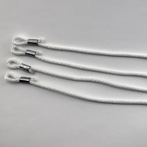 Four Leclerc roller cords, designed for Mira and Fanny Looms by Leclerc Looms, lie parallel on a plain grey background. Each white braided cord features a neatly formed loop at one end secured with a silver metal clamp, suggesting they are intended for hanging or securing objects.