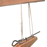 A Leclerc Treadle Hook from Leclerc Looms is shown in the image. The hook features two strings attached to it, which are secured onto a rod, suspended from a horizontal wooden beam, forming a simple hanging mechanism.