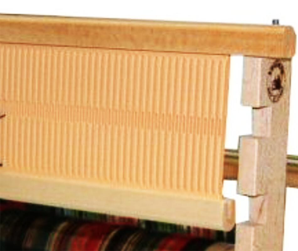 A close-up of the Leclerc 24" Bergere Rigid heddle Reed by Leclerc Looms, crafted from light-colored wood and metal. The reed, featuring evenly spaced vertical slots, occupies most of the frame. The lower part of the loom with warp threads is partially visible.