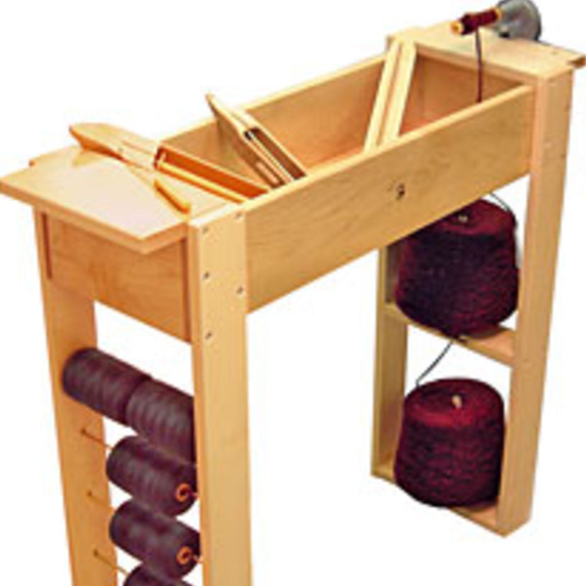 The Leclerc Holds-All Winding Station by Leclerc Looms is a wooden spinning wheel featuring a built-in compartment that efficiently holds fiber and tools. It includes spools of thread stored on shelves located on the side and below, with a spool rack for easy access. The design is simple, showcasing a perfect blend of functionality and craftsmanship.