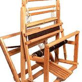 The Leclerc Fanny II 4-shaft Floor Loom by Leclerc Looms is a wooden handloom weaving machine featuring a detailed structure with various components, including a frame, pedals, and mechanisms for holding and manipulating threads. It showcases the traditional design used for textile weaving.