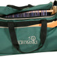 A Kromski Bag for Harp Rigid Heddle Loom (Green) with black straps and a front pocket is partially open, revealing a Harp loom with colorful yarn and a wooden weaving tool inside. The word "Kromski" and a wheel logo are printed on the front pocket.