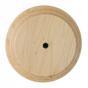 A Schacht Whorl by Schacht Spindle Co. features a circular wooden design with a natural grain pattern and a small black screw or hole in the center, and its surface is smooth and polished.