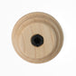 A Schacht Whorl by Schacht Spindle Co. is depicted as a wooden circular piece featuring concentric grooves and a central hexagonal socket. The wood showcases a light, natural finish while the socket is dark in color, all set against a white background from an overhead perspective.