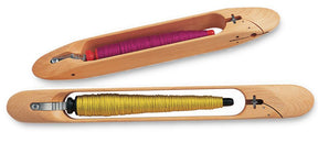 Two Schacht End Delivery Shuttles, by Schacht Spindle Co., are displayed. The shuttle at the top holds a spool of purple thread, while the shuttle at the bottom holds a spool of yellow thread. Each wooden weaving shuttle features a simple, elongated design with a slot for even tension threading.