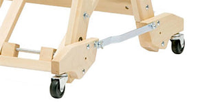 Close-up image of the base of the Schacht Wolf Stroller, showcasing its wheel mechanisms. The stand, produced by Schacht Spindle Co., includes a metal support bar and two caster wheels attached to the bottom, presumably for easy mobility. The background is white.