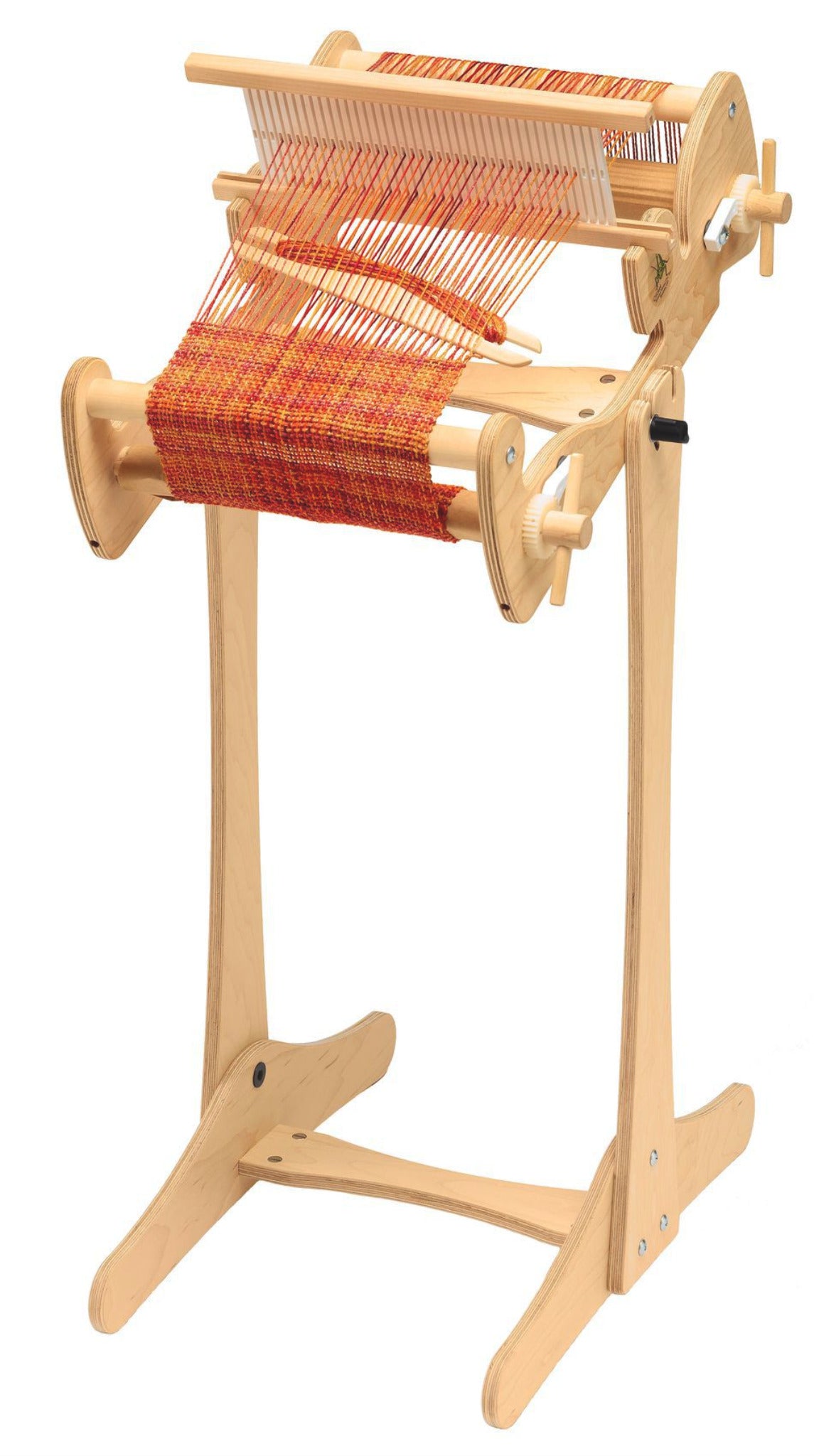 A high-quality Schacht Cricket Loom, featuring vibrant orange and red threads stretched across it, stands proudly on a Schacht Cricket Floor Stand from Schacht Spindle Co. The wooden frame boasts adjustable components and side knobs. It appears to be in use, with some woven fabric partially finished.