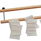 A Schacht Rigid Heddle Loom Variable Dent Reed w/Segments by Schacht Spindle Co. features a wooden frame with a metal rod, accompanied by several white plastic comb-like pieces laid out below it. These variable dent reeds have evenly spaced slots, indicating they are used for yarn or textiles.