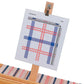 A weaving loom by Schacht Spindle Co. displays a color pattern made of blue and red threads, held on a stand with a clip that shows a grid with intersecting lines. Equipped with the Schacht Treadle Tracker, the loom’s partly woven fabric mirrors the pattern's blue and red striped design.