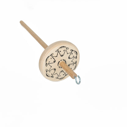 The Louët High-Whorl Drop Spindle by Louët Inc. is a wooden spindle with a circular whorl decorated with repetitive sheep illustrations. There is a metal hook attached at its top end, giving it a simple, rustic appearance. This spindle is photographed against a plain white background.