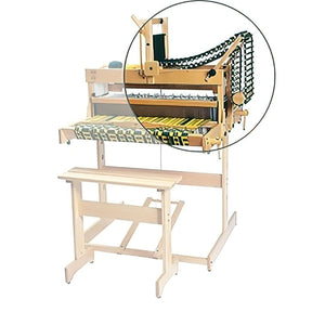 A Louët Magic Dobby Head weaving loom by Louët Inc., complete with a matching bench, is shown. The loom displays a partially woven black and yellow textile. An inset circular magnification provides a closer view of the loom's intricate yarn threading and mechanics.