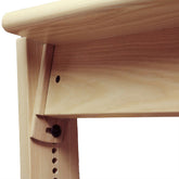 Close-up of the Louët Bench Tilting Kit for Delta / Octado / Megado Loom Benches by Louët Inc., showing a detailed joint mechanism. The light-colored wood features a round knob for adjustments, along with vertical notches and an angled support piece that suggests adjustability in height or angle.