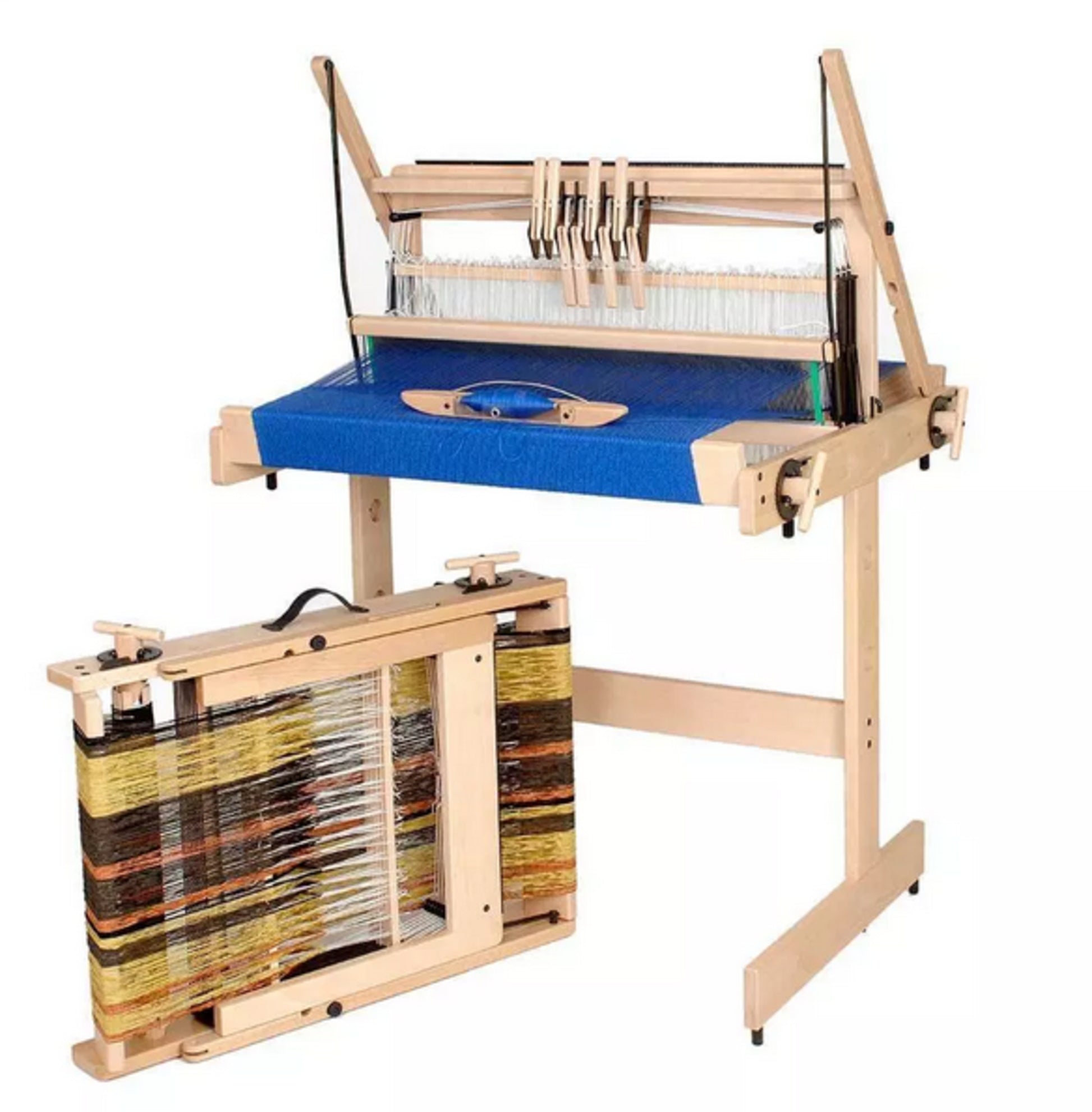 A Jane Table Loom from Louët with multiple strings set up for weaving, featuring a blue textile in progress. On the left, a Louët Inc. Louët Loom Floor Stand holds yarn of various colors. The loom and frame are set against a plain white background.