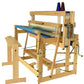 A Louët Octado 8-shaft Floor Loom without Dobby Control Head by Louët Inc. with blue fabric partially woven on it. The loom features various levers, pedals, and spools of thread, one purple and one blue, mounted on the right side. A small bench is positioned in front of the loom.